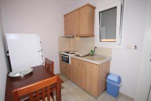 a small kitchen with a sink and a refrigerator at Coralli Studios in Ormos Panagias +13 photos