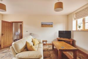 a living room with a couch and a tv at Cleeton Cottage in Elmbridge