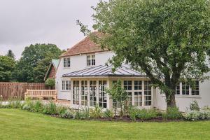 a white house with a bench in a yard at Bridlepath Cottage in West Woodhay