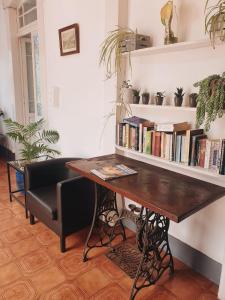 a desk with a chair and a book shelf with books at Hospedaria Pôr do Sol in Funchal