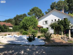 een wit huis met een bad in de tuin bij Chambres d'Elisa in Saint-Morillon