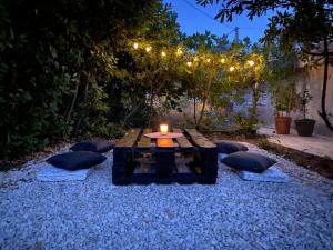 stół ze świecą na szczycie żwirowego patio w obiekcie Apartment Oliveglia w mieście Šilo