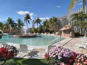 uma piscina com cadeiras e uma fonte em ADTUR Flats CTC - Condomínio Saphire ou Center Caldas em Caldas Novas