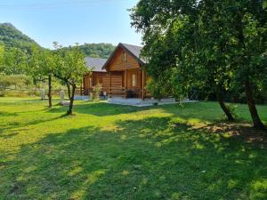 a log cabin with trees in front of it at Little Paradise in Virpazar