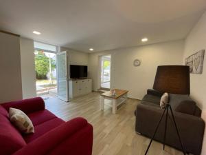 salon z czerwoną kanapą i telewizorem w obiekcie Apartment Oliveglia w mieście Šilo