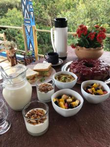 una mesa cubierta con tazones de comida y leche en Entre Montanhas Capão, en Vale do Capao