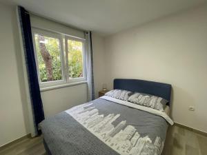 sypialnia z łóżkiem i oknem w obiekcie Apartment Oliveglia w mieście Šilo