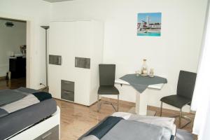 Cette chambre comprend deux lits, une table et des chaises. dans l'établissement Ferienwohnung Jagsthausen, à Jagsthausen