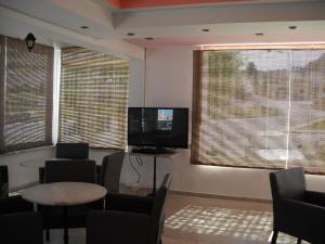 a room with chairs and a table and a television at Antonis Hotel in Kefalos