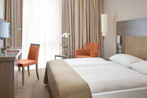 
a hotel room with two beds and a television at IntercityHotel Berlin Hauptbahnhof in Berlin
