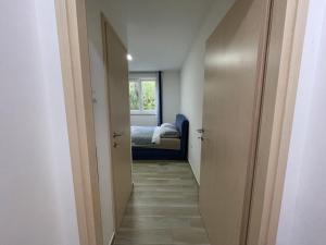 korytarzem prowadzącym do sypialni z łóżkiem w obiekcie Apartment Oliveglia w mieście Šilo