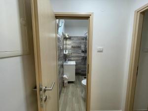 łazienka z toaletą, umywalką i drzwiami w obiekcie Apartment Oliveglia w mieście Šilo
