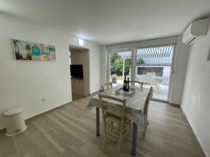 kuchnia i jadalnia ze stołem i krzesłami w obiekcie Apartment Oliveglia w mieście Šilo +8 zdjęć