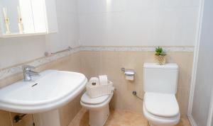 a bathroom with a white toilet and a sink at Chalet cerca a la playa con jardín y barbacoa in Tarragona +16 photos