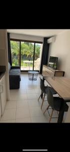 sala de estar con mesa y escritorio con ordenador portátil en Appartement agréable en bord de mer, en Villefranche-sur-Mer