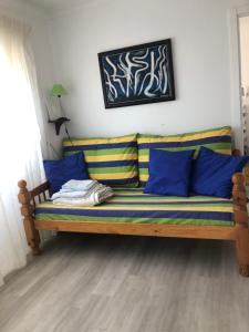 ein Sofa mit blauen und gelben Kissen in einem Zimmer in der Unterkunft Villa Praia in São Martinho do Porto + 43 Fotos