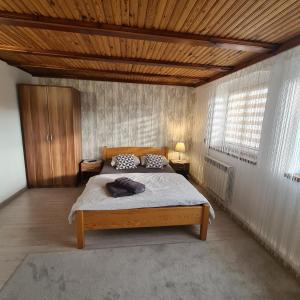 a bedroom with a bed and a wooden ceiling at Apartament OLTO Mikołajki in Mikołajki