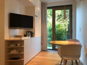 een keuken met een tafel en een tv aan de muur bij Het Nekkerhof B&Bio in Mechelen