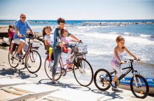 un grupo de niños montando bicicletas en la playa en Hotel Virginia, en Diano Marina