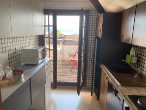 a kitchen with a door leading to a deck with a patio at Beauregard attique in Lausanne