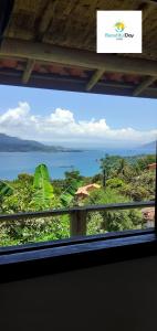 una ventana de una casa con vistas al océano en Beautiful day suítes, en Ilhabela 22 fotos más