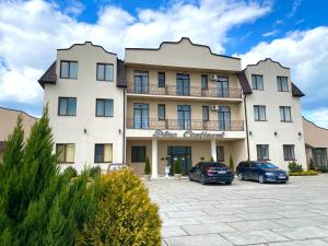 a large building with two cars parked in a parking lot at New Continent in Bushtyno