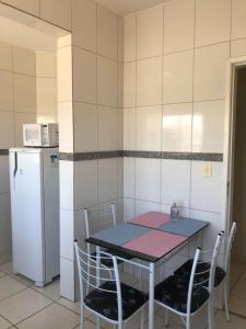 uma cozinha com uma mesa e cadeiras e um frigorífico em Apartamento com varanda em Lavras