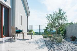 a chair on a patio with a view of the ocean at Encanto Agriturismo & Private SPA in Visogliano