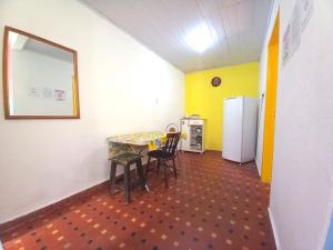a room with a table and chairs and a refrigerator at Infinito House - Casa inteira in São Paulo