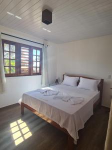 una camera da letto con un grande letto con asciugamani di Pousada Ventos do Guajiru-Casa de Kitesurfistas a Itarema