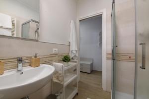 a white bathroom with a sink and a shower at Le stanze di Gió in Teramo