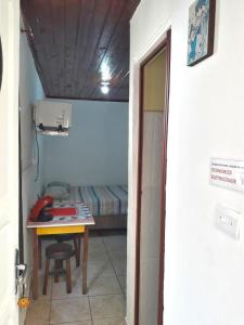 ein kleines Zimmer mit einem Tisch und einem Bett in der Unterkunft Infinito Suíte in São Paulo