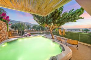 a swimming pool in a backyard with a tree at Notos Heights Hotel & Suites in Malia