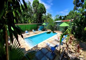 a swimming pool with chairs and umbrellas in a yard at Bak A Yaad in Negril