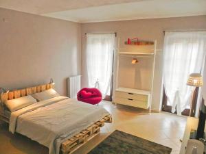 um quarto com uma cama grande e uma cadeira vermelha em La Casa di Milly em Alba
