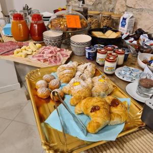 una mesa con una bandeja de bollería y otros alimentos en Bed and Breakfast La Coa, en Auronzo di Cadore