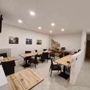 uma sala de jantar com mesas e cadeiras de madeira em Bed and Breakfast La Coa em Auronzo di Cadore