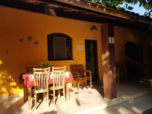 a table and chairs on the porch of a house at Chalés e flats Recanto Primavera in Camburi +86 photos