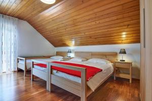 a bedroom with two beds and a wooden ceiling at Rooms Pevc & Hostel Ljubno ob Savinji in Ljubno