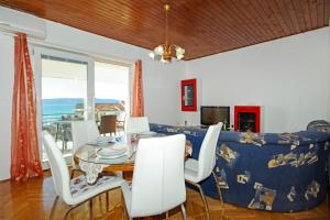 a dining room with a table and a couch at Apartmani ANDRIJA in Živogošće