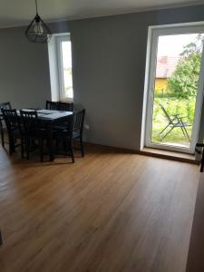 a dining room with a table and chairs and a window at Apartament Wydminy in Wydminy +2 photos