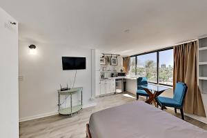een hotelkamer met een bed, een bureau en een keuken bij Hawaiian Monarch 805 condo in Honolulu