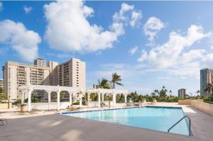 een zwembad met een prieel naast gebouwen bij Hawaiian Monarch 805 condo in Honolulu