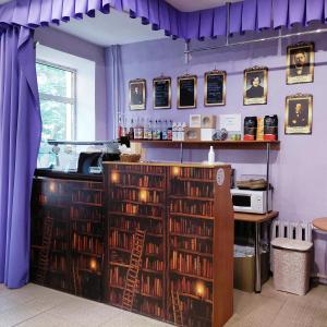 ロデイノイェ・ポリェにあるSvir Mini-Hotelの紫の壁の客室、本のあるバー