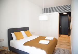 a bedroom with a bed with two towels on it at FLH Praça Comércio Wood Design Flat in Lisbon