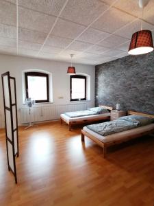 um quarto com duas camas e uma parede de tijolos em Geräumige Wohnung in zentraler Lage em Emskirchen