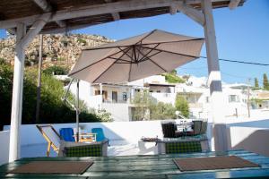 a table with an umbrella and chairs on a patio at Traditional house Utopia Makri Gialos in Pévkoi