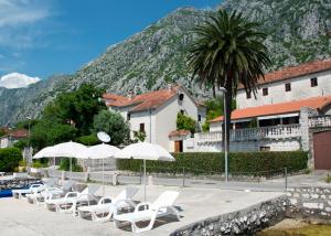 a group of chairs and umbrellas in front of a building at Apartments Radonicic in Kotor