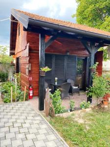 a wooden cabin with a patio with a table at Hotel Guesthouse Stari Jasen in Zagreb