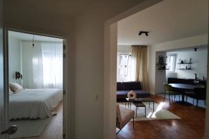 a bedroom with a bed and a living room with a table at De Flat - Licht en luxueus appartement bij Het Zuid in Antwerp